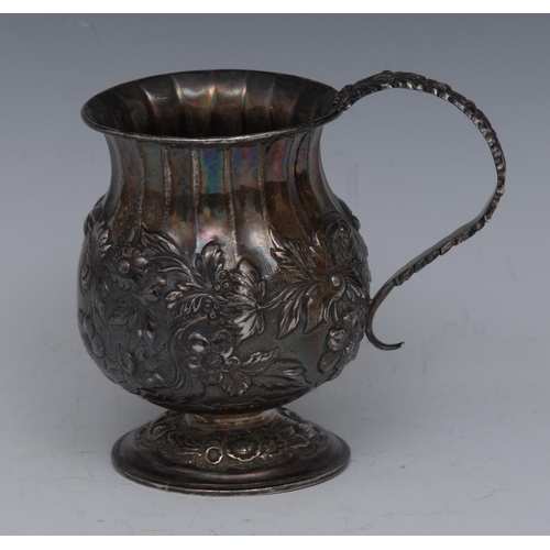 79 - A George IV silver bulbous fluted mug, chased with a band of flowers and scrolling foliage, acanthus... 