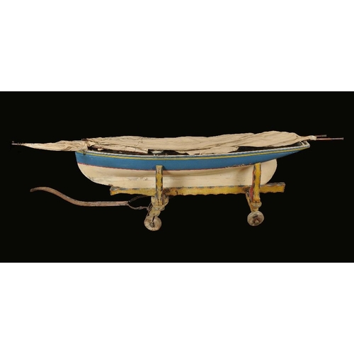 1621 - An unusually large scratch built model yacht, 174cm long, wooden trolley, brightly painted in fairgr... 