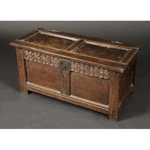 1630 - A 17th century oak child's two panel blanket chest, hinged top above a deep frieze carved with two r... 