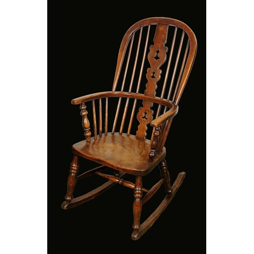 1646 - A 19th century elm Windsor rocking elbow chair, hooped back, shaped and pierced 'Christmas tree' spl... 