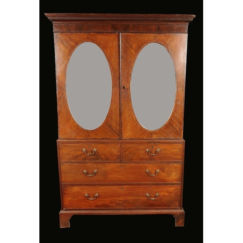 1703 - A George III mahogany linen press, dentil cornice above a pair of oval mirrored doors, the base with... 