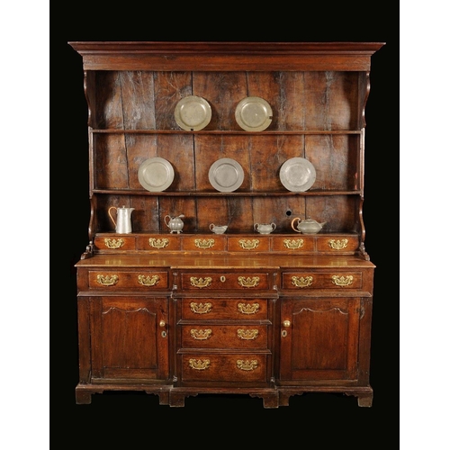 1718 - A George III oak dresser, moulded outswept cornice above three open shelves and a row of six small d... 