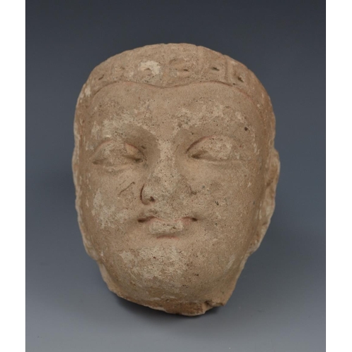 2560 - Antiquities - an Indian sandstone fragment, carved as the head of deity,  10cm high