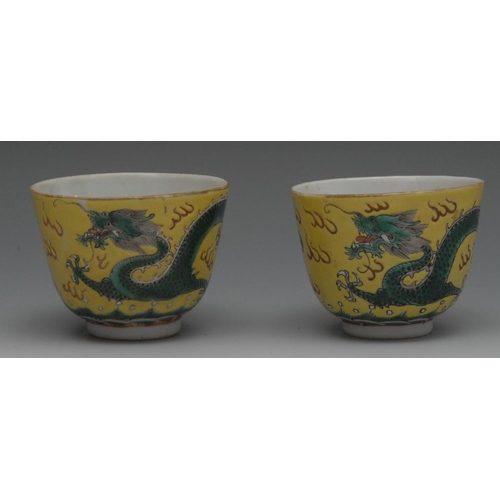 65 - A pair of Chinese porcelain tea bowls, brightly painted with dragons chasing the flaming pearl, 6cm ... 