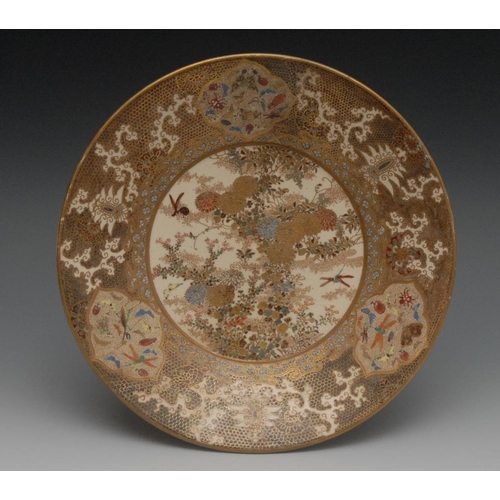 82 - A Japanese satsuma circular dish, painted in polychrome and gilt with flowers and insects, 23cm diam... 