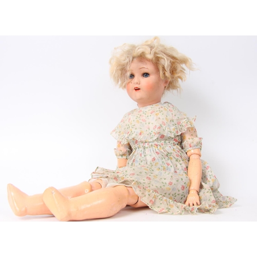 307 - A sprayed bisque head and composition jointed body doll, sleeping blue glass eyes, painted features,... 