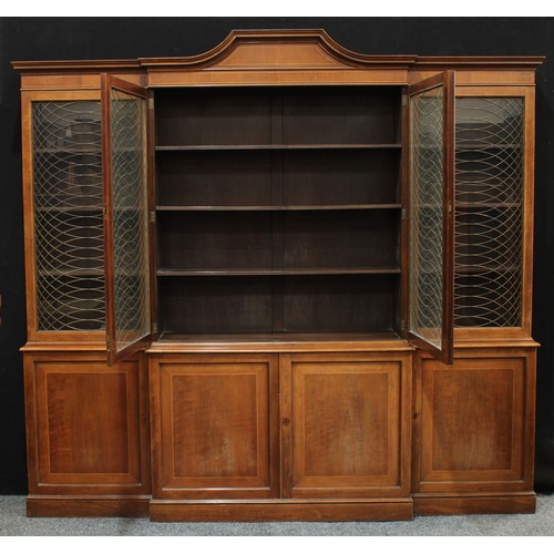 147 - A regency design brake centre library bookcase, arched outswept cornice above four glazed doors appl... 