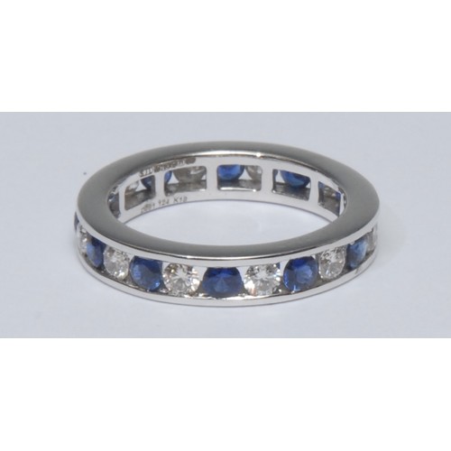 781 - A diamond and sapphire eternity ring, open channel alternate set with twelve round brilliant cut dia... 