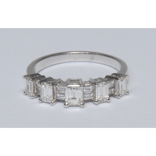 775 - A contemporary design graduated step cut diamond ring, five graduated raised tower claws each inset ... 