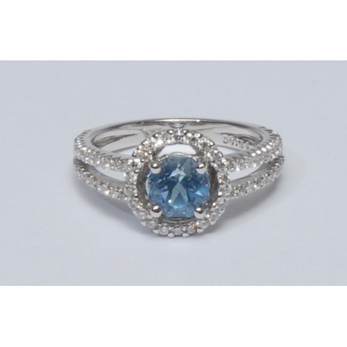 822 - An aquamarine and diamond cluster ring, central circular aquamarine quarter claw set within an surro... 