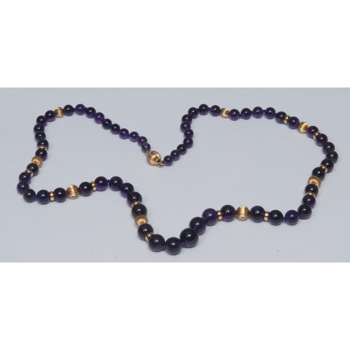 794 - A graduating amethyst and gold bead necklace, tapering amethyst beads section-ally divided by twenty... 