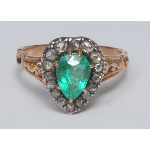 829 - An emerald and diamond cluster ring, central pear cut emerald, measuring approx 7.6mm x 5.7mm x 4.2m... 