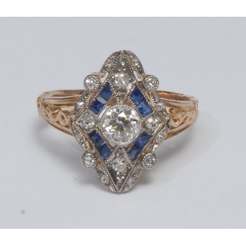 824 - An Art Deco style sapphire and diamond cluster ring, open cast shield crest inset with a central rou... 