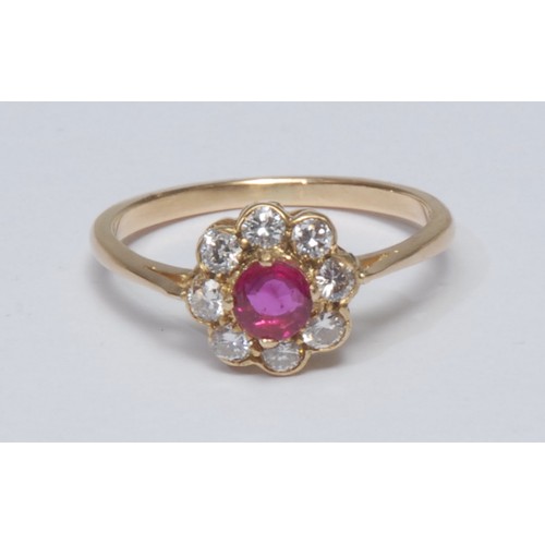 780 - A diamond and ruby cluster ring, central round cut ruby surrounded by a collar of eight brilliant cu... 