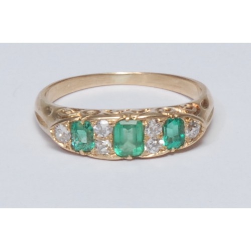 832 - An emerald and diamond line ring, tapering crest inset with six mixed cut diamonds and three oval an... 