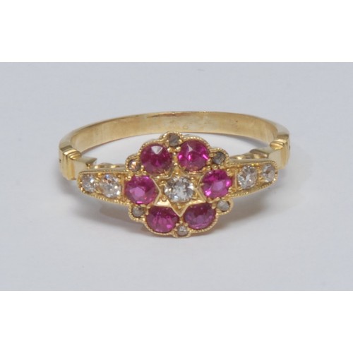 779 - A diamond and ruby cluster ring, central oval mixed old cut diamond surrounded by a ring of six vibr... 