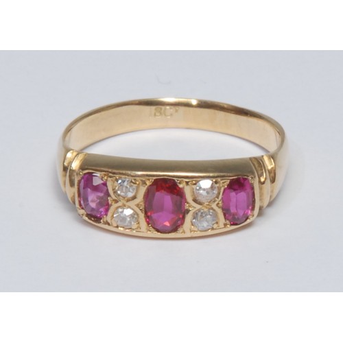 808 - A ruby and diamond ring, inset with three oval cut red rubies, each divided by a pair of old brillia... 