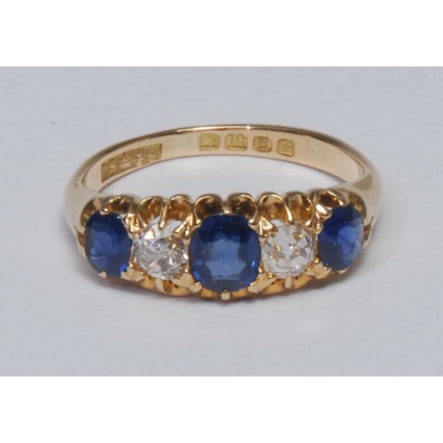 817 - A sapphire and diamond quintet ring, linear set with three graduated oval and mixed cut blue sapphir... 