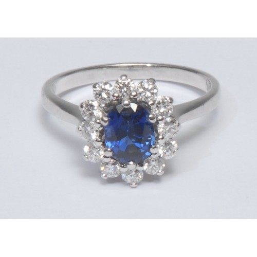 810 - A sapphire and diamond cluster ring, central oval vibrant blue sapphire, approx 1.04ct surrounded by... 