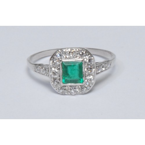 830 - An emerald and diamond cluster ring, central rectangular baguette cut emerald, approx 0.40ct, surrou... 