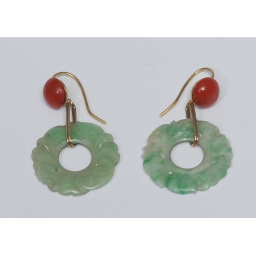 803 - A pair of carved green stone and coral drop earrings, each with a carved floral green stone ring dro... 