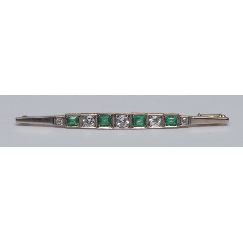 828 - An emerald and diamond bar brooch, alternate set with five round brilliant and four cushion and bagu... 