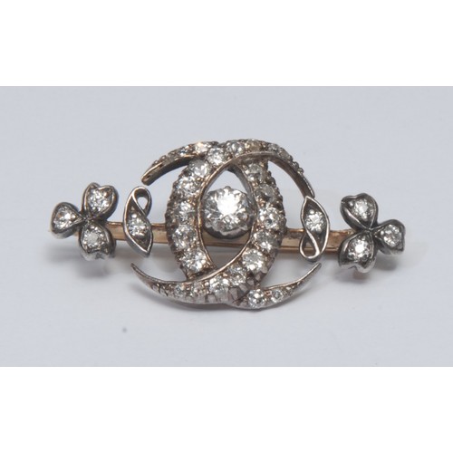 827 - An Edwardian diamond brooch, interlaced overlapping crescents surrounding a single diamond, all with... 