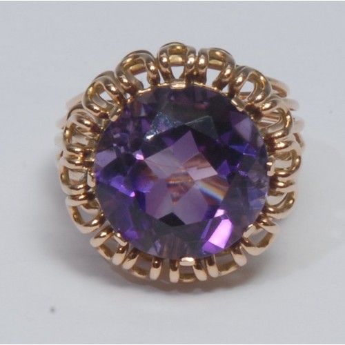 805 - A retro amethyst dress ring, large vibrant purple amethyst within gold coloured wire work petal cres... 