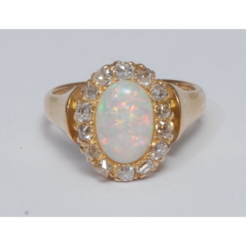 837 - An opal and diamond cluster ring, oval cabochon opal flashing vibrant orange, red, green and violet ... 