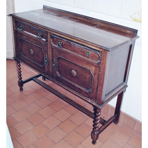 100 - A Jacobean Revival oak sideboard, slightly over-sailing top above a pair of drawers and cupboards, a... 