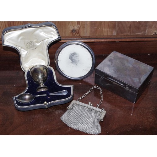 253 - A silver rectangular cigarette box, 11.5cm wide, London 1914;  a silver egg cup and spoon, Goldsmith... 