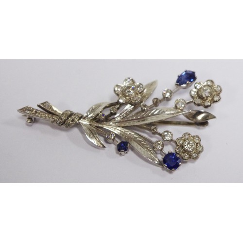 310 - A diamond and sapphire floral spray brooch, the three open flowerheads set with brilliant cut stones... 