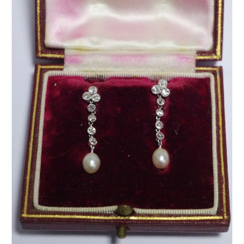 324 - A pair of diamond, pearl and white metal pendant stud earrings, with a cluster of three brilliant cu... 