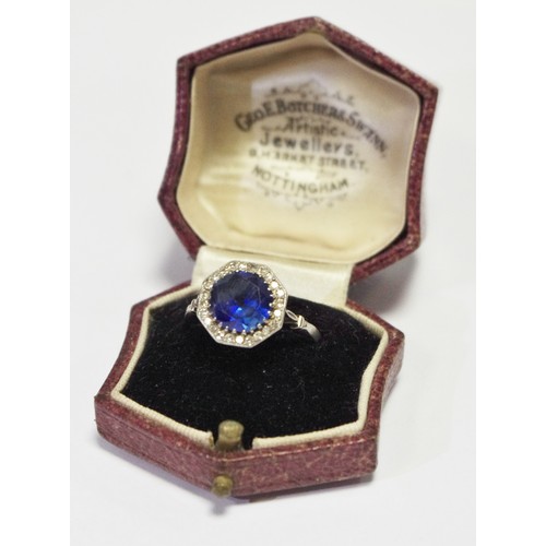 325 - A sapphire and  diamond cluster lady's ring, the large central sapphire of good colour, within a sin... 