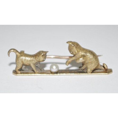 341 - A yellow metal bar brooch heavily cast with two kittens playing with a 'pearl' ball, diamond chip se... 