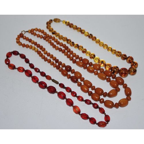 343 - A two string butterscotch amber necklace, with alternating egg and bun shaped beads, 51g;  a single ... 