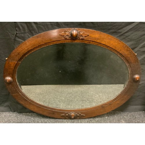 100 - A 1930s oval oak framed wall mirror, bevelled plate, roundel adorned frame, 85cm x 60cm overall;  a ... 