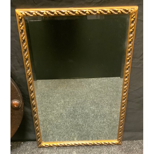 100 - A 1930s oval oak framed wall mirror, bevelled plate, roundel adorned frame, 85cm x 60cm overall;  a ... 