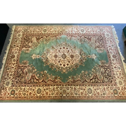 105 - A Super Keshan carpet, central floral medallion within pale green ground,  scrolling corner field al... 