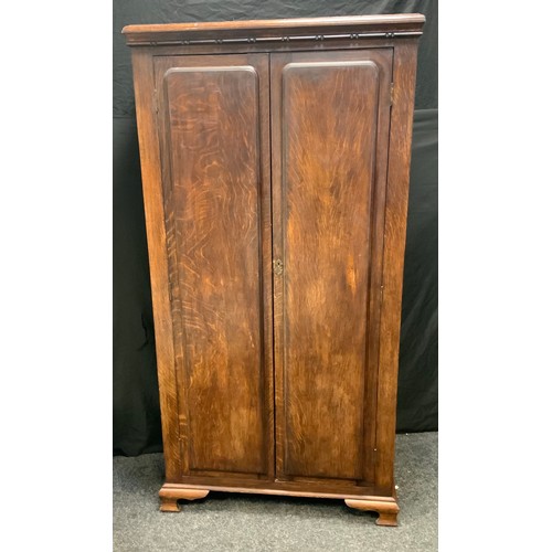 133 - A mid 20th century oak three piece bedroom suite, two door wardrobe, mirror backed narrow two drawer... 