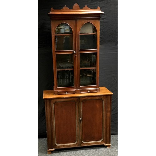 191 - A Victorian mahogany and stained pine bookcase top, shaped pediment, two arched glazed doors over tw... 