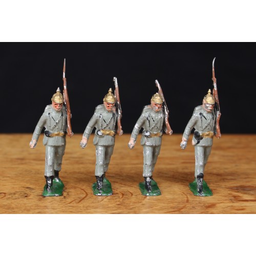 5229 - A group of four painted lead figures as WWI German infantry, each marching at the trail, wearing gol... 