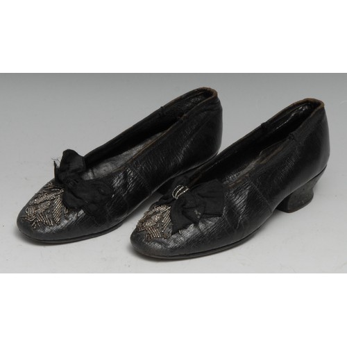 3588 - Costume - a pair of late George III children's black leather court shoes, the silk bows and toes app... 