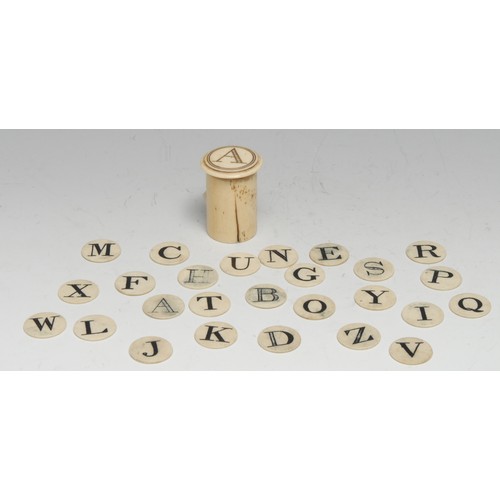 3012 - A 19th century bone child's teaching spelling alphabet, the circular counters contained within a cyl... 