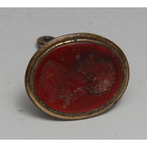 3248 - A late George III gilt-metal fob seal, enclosing an intaglio matrix in the Grand Tour taste of a sta... 