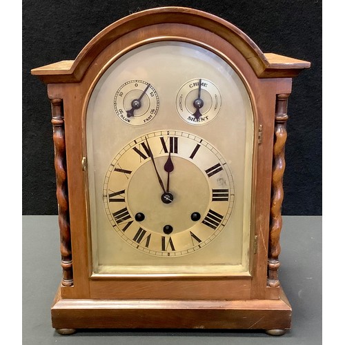 57 - A mahogany dome top mantel clock, arched face, Roman numerals, flanked by barley twist columns, bun ... 