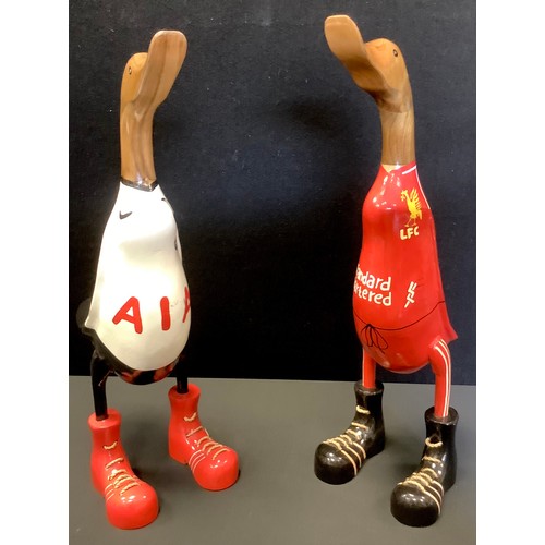 95A - A wooden duck, standing, wearing football shirt, 47cm high;  another (2)