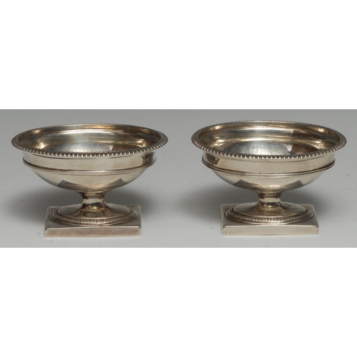 156 - A pair of Victorian cast silver oval pedestal salts, of George III design, gadrooned borders, rectan... 