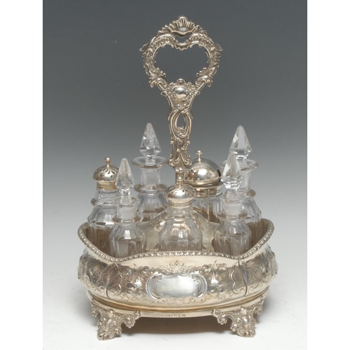 176 - A Victorian silver boat shaped seven-bottle cruet, chased throughout with flowers, stiff leaves and ... 