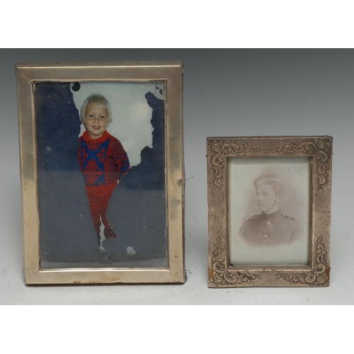 185 - A Victorian silver rectangular easel photograph frame, embossed to the angles with flowers and leafy... 